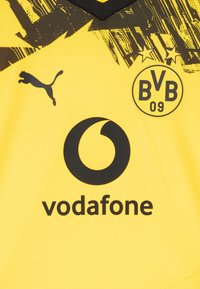 Camiseta de fútbol amarilla y negra del Borussia Dortmund con el logo de Puma y el logo del patrocinador Vodafone.