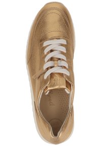 Guldmetallisk sneakers med vita snören, rund tå och perforerad sula. Har en slät yta och minimalistisk design.
