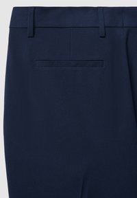 Marineblaue Hose mit glatter Textur, ausgestattet mit einer einzigen Gesäßtasche und Gürtelschlaufen, entworfen mit einer taillierten Passform.