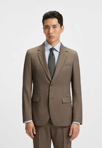 Brown tailored suit jacket with notched lapels, two front pockets, and single-button closure over a light blue striped shirt and patterned tie.
