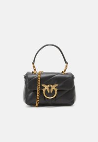 Sac à main en cuir noir avec un design matelassé, une bandoulière en chaîne dorée et un motif d'oiseau décoratif sur un fermoir circulaire. Texture lisse, forme compacte.