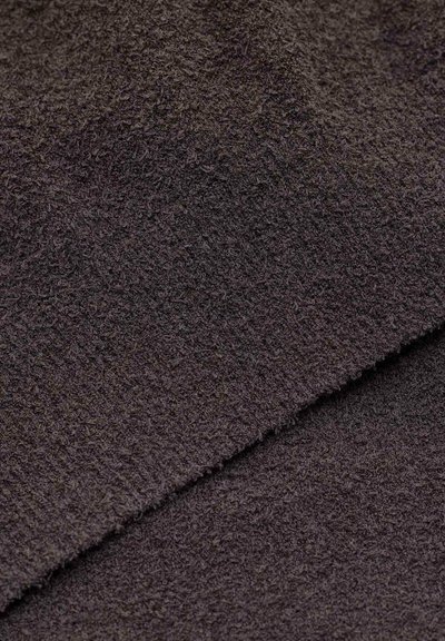 Asciugamano marrone scuro con una superficie morbida e testurizzata e fibre arricciate, che mostra un design spesso e lussuoso. I bordi sono rifiniti in modo ordinato.