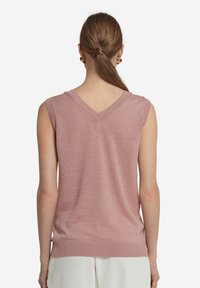 Ärmlös rosa stickad topp med V-ringning och ribbad nederkant, slät yta och något figursydd silhuett. Bakifrån visas detaljer vid axelsömmarna.