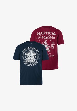 Camiseta azul marino con pirata con el texto "Work like a captain, play like a pirate" y camiseta roja con barco de vela y texto "Nautical Heritage".