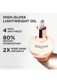 Kérastase Glaze Drops, un aceite ligero de alto brillo en un frasco redondo de vidrio transparente con un cuentagotas blanco y detalles en dorado rosa.