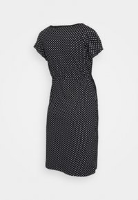 Czarna sukienka w kropki z krótkimi rękawami, luźnym krojem i długości do kolan, posiadająca marszczoną talię dla podkreślenia sylwetki.