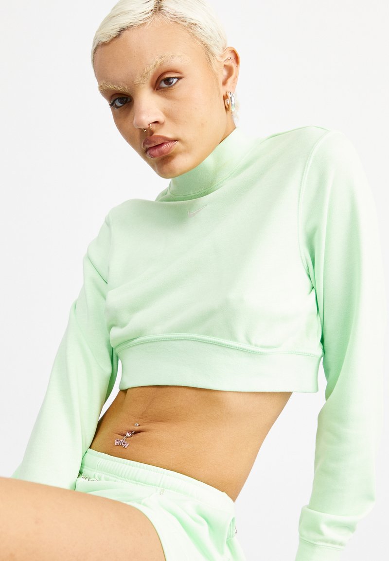 Sudadera corta de color verde menta en un tejido suave con un alto cuello y mangas largas, que presenta un pequeño logo en el pecho.