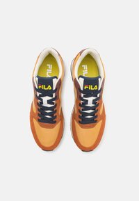 Multicolored sneakers featuring orange and brown suede, navy laces, white accents, and a bright yellow insole. Fila branding on tongue.