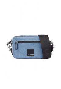 Blue denim crossbody bag with a zippered front pocket, black adjustable strap, and a logo patch on the side. Rectangular shape with textured finish.