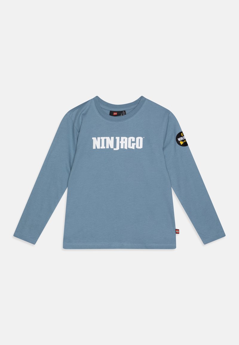Langärmliges blaues Baumwoll-T-Shirt mit weißem "NINJAGO"-Schriftzug auf der Vorderseite und rundem Ausschnitt sowie einem schwarzen Patch am Ärmel.