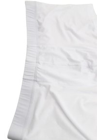 Tessuto bianco con una superficie liscia; presenta una cintura elastica e una tasca laterale, enfatizzando un design pulito e minimalista.