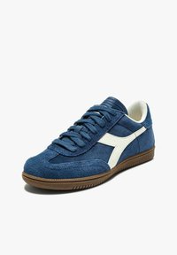 Sneakers in suede blu con accenti bianchi in stile retro. Punta arrotondata, design con lacci piatti, suola di gomma testurizzata e collo imbottito.
