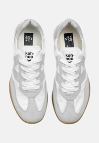 Sneaker bianche e grigie con tomaia in suede e tessuto, caratterizzate da una punta tonda, lacci bianchi e suola in gomma color gomme. Design minimalista.