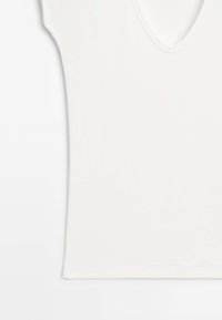 Plain white short-sleeve shirt with a V-neck collar laid flat on a white surface.