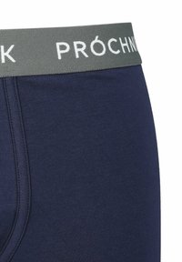 Granatowe bokserki z miękkiego, elastycznego materiału; posiadają szary elastyczny pas z napisem "PRÓCHNIK" w białym kolorze.
