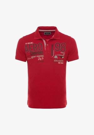 Polo rossa a maniche corte con colletto e testo stampato sul davanti che include "AERO," "CARISMA," "98" e "ADVENTURE".