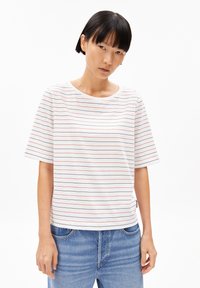 White short-sleeve T-shirt featuring thin red horizontal stripes, round neckline, and a relaxed fit. Paired with light blue denim jeans.