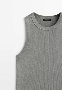 Haut gris sans manches en maille côtelée avec un col rond et une étiquette de marque noire à l'intérieur du col.
