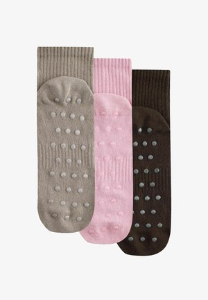 Drei Paar gerippte, rutschfeste Socken in Beige, Rosa und Dunkelbraun, jeweils mit erhabenen Griffpunkten an den Sohlen.