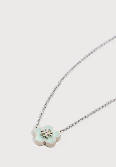 Ασημένιο κολιέ με αλυσίδα και μικρό φωτεινό γαλάζιο μενταγιόν τετράφυλλου τριφυλλιού, με ανάγλυφο ασημένιο λογότυπο στο κέντρο.