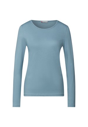 Camicia a maniche lunghe di colore azzurro chiaro. Realizzata in un tessuto morbido ed elastico con scollatura rotonda e silhouette aderente. Senza motivi o accenti visibili.