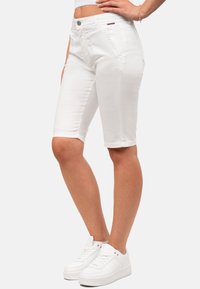 Shorts en denim blanc avec une coupe slim, design classique à cinq poches et fermeture à bouton. Présente des coutures visibles et une texture lisse.