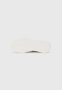 Shoe sole with a textured, white rubber material. Features patterned grip designed for traction, with a geometric design and beveled edges.