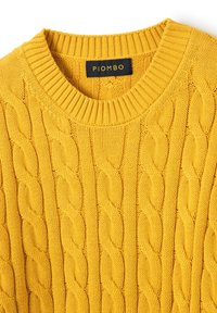 Gelber gestrickter Pullover mit Kabelmustern, einem runden Rippenkragen und einem auf goldenem Hintergrund in Schwarz gestickten Etikett mit der Aufschrift "PIOMBO".