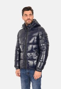Giacca puffer blu navy con finitura lucida, chiusura con zip e cappuccio. Presenta un design trapuntato e tasche laterali per la funzionalità.