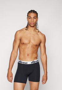 Svarta boxerkalsonger med vit midja och "ellesse"-logotyp. Den mjuka tyget och den åtsittande designen ökar komforten och stödet.