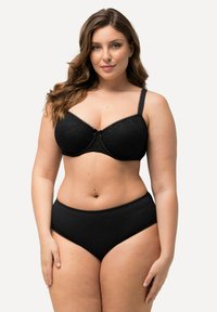 Zwarte kanten beha met beugel, verstelbare bandjes en een strikaccent. Hooggerote zwarte slip met een textuurpatroon en kantafwerking.