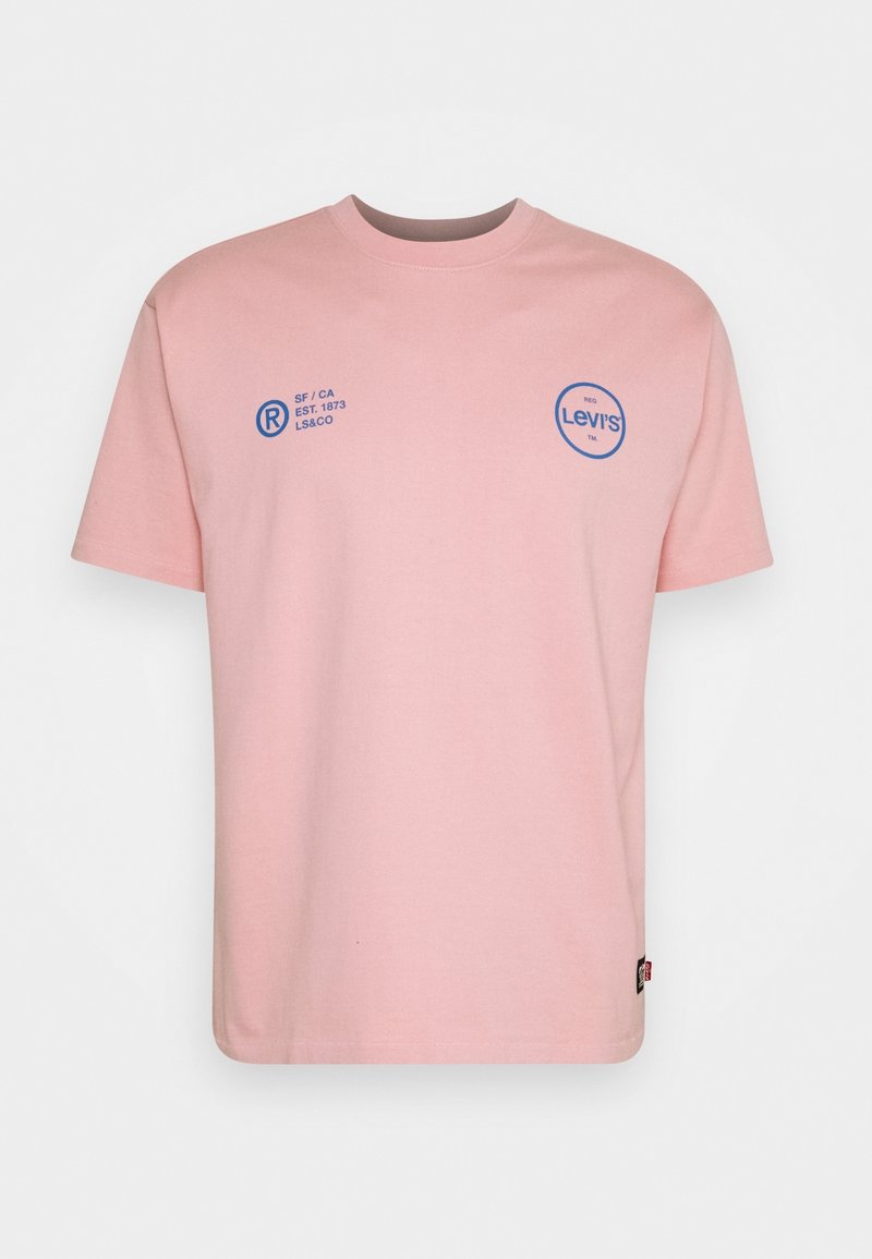 T-shirt en coton rose avec un col rond, des manches courtes, un logo Levi's bleu et un texte sur la poitrine, ainsi qu'une petite étiquette rouge sur la couture latérale.