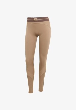 Beige leggings met een textured, donkerbruine tailleband, voorzien van gebogen naaddetails en een aansluitende pasvorm voor sportkleding.
