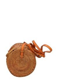 Borsa rotonda in paglia intrecciata con tracolla in pelle color tan. Caratterizzata da un fondo piatto e una forma circolare, mette in evidenza un intreccio e una cucitura intricati.