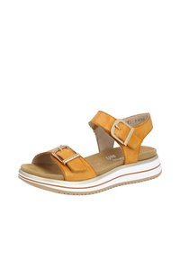 Orange lädersandal med två spännen, en vadderad sula och en vit plattformssula med texturerad undersida.