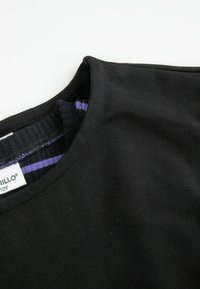 Czarny bawełniany t-shirt z okrągłym dekoltem. Wewnątrz cechuje się wzorem w paski w kolorze fioletowym i czarnym. Gładka tekstura, swobodny design.