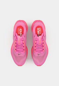 Rosa Sportschuhe mit atmungsaktivem Mesh-Obermaterial, lebhaft rosanem Sohlenrand und gepolstertem Zungenbereich mit Branding. Die Schnürsenkel sind strukturiert und auffällig.