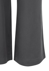 Pantalon gris foncé à jambes droites montrant la texture détaillée du tissu et les coutures de l'ourlet sur fond blanc.