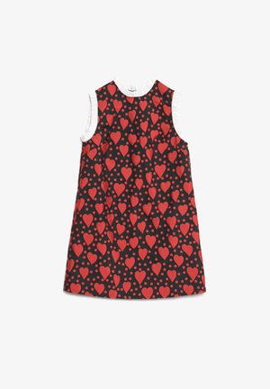 Vestido negro sin mangas con estampado de corazones rojos y puntos, con un ribete blanco con volantes alrededor de las sisas y el escote.