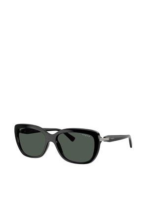 Lunettes de soleil noires oversize forme œil de chat avec verres teintés foncés et branches fines ornées d’un petit détail en strass près des charnières.