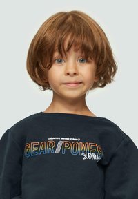 Felpa di un blu scuro con testo colorato "GEAR/POWER" e logo. Collo rotondo e tessuto morbido. Spalla di un bambino visibile.
