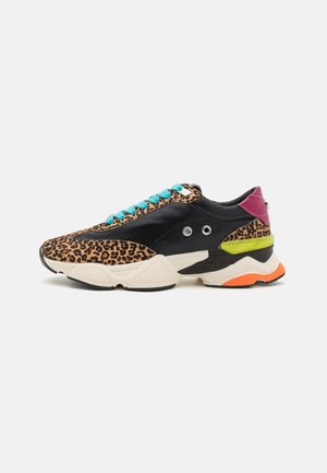 Chunky sneaker with leopard print, black panels, blue laces, pink heel, yellow accent, and orange-tipped white sole side view on white background.