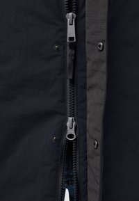 Dunkle, leichte Jacke mit einem auffälligen Reißverschluss, Druckknopfverschluss und fächerförmigem Futter. Verfügt über eine glatte, matte Textur.