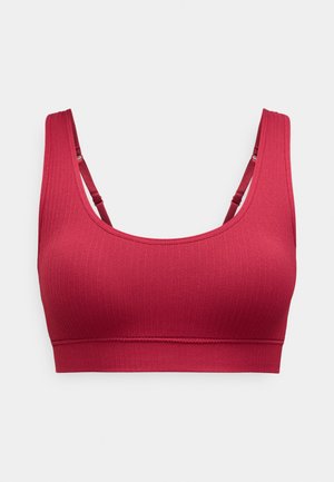 Rode geribde sportbeha met brede banden, ronde halslijn en een brede onderband. Zacht stoffen textuur met minimale naden en geen padding.