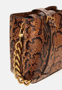 Borsa in pelle di serpente marrone con superficie texture, dotata di una tracolla in catena dorata e di una chiusura sicura. Accenti in pelle evidenziano il suo design.