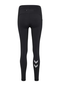 Sorte leggings lavet af elastisk materiale med en tætsiddende pasform, der har en ryglynlåslomme og et sølvfarvet chevronmønster på underbenet.