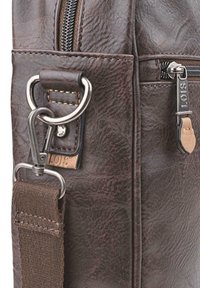 Bolso de cuero marrón con material texturizado, cierre de cremallera, herrajes plateados y una correa de tela desmontable con detalles de costura.