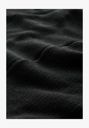Black knit fabric with a soft, textured surface. The material shows subtle ridges and variations, enhancing its visual depth.