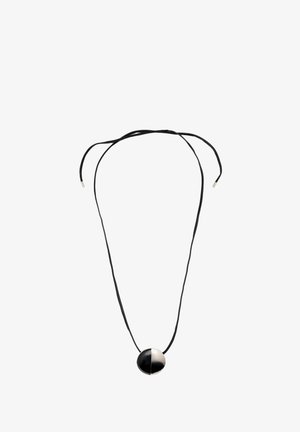 Schwarzes und weißes rundes Anhänger-Halsband an einer schwarzen Schnur. Der Anhänger hat eine glänzende Oberfläche, ein geteiltes Design und silberne Akzente an den Enden.