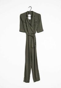 Olivenfarbener Jumpsuit, leichtes Material, Wickeldesign mit gebundenem Taillenband, kurze Ärmel, zwei vordere Taschen und ein Aufhänger am Kragen.